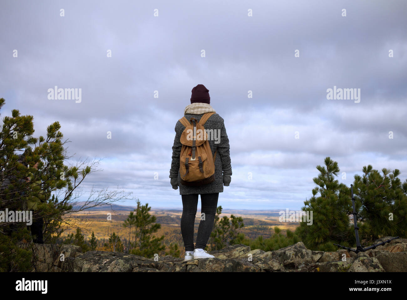 Young woman standing on mountain, looking at view, Sverdlovsk Oblast, Russia Stock Photo