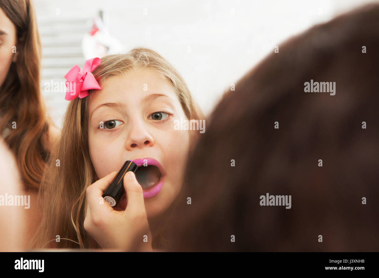 Girls applying makeup in mirror Stock Photo Alamy