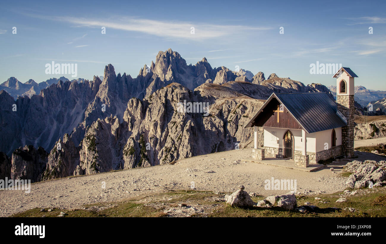 Chapel of the Alpini in the Italian Dolomites on a clear blue sky day. Mountains and Alpine scenery in the background. Stock Photo