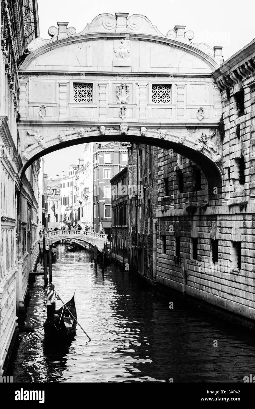 Ponte dei sospiri with a gondola floating towards it. Venice, Italy. Black and white. Stock Photo