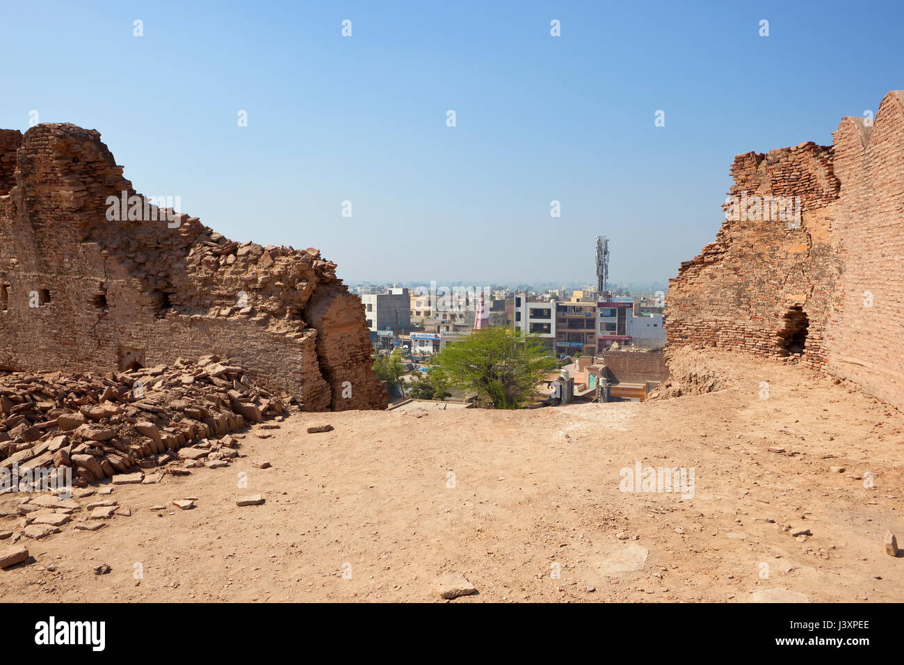 hanumangarh city rajasthan india viewed from walls undergoing restoration at bhatner fort with brick rubble and acacia trees under a blue sky in sprin Stock Photo