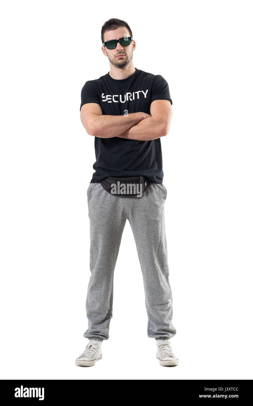 Serious tough macho police man in civil clothes with crossed arms looking at camera. Full body length portrait isolated on white studio background. Stock Photo