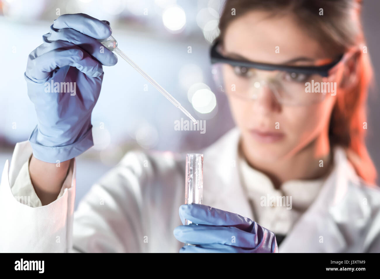 Young scientist pipetting in life science laboratory. Stock Photo