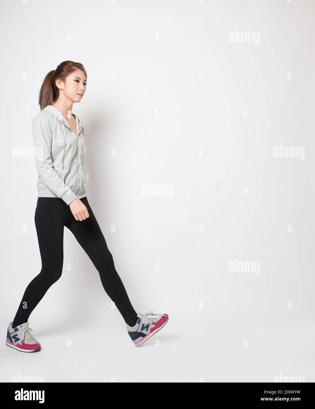 Beautiful slim girl walking on a white background Stock Photo Alamy