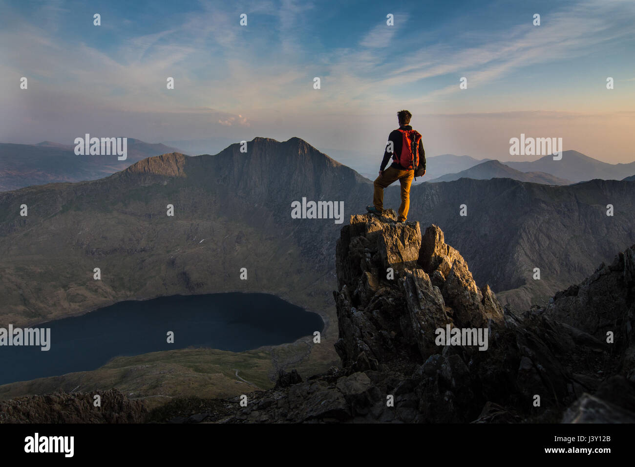 mountaineer on ridge overlooking mountains on Crib Coch North Wales Stock Photo