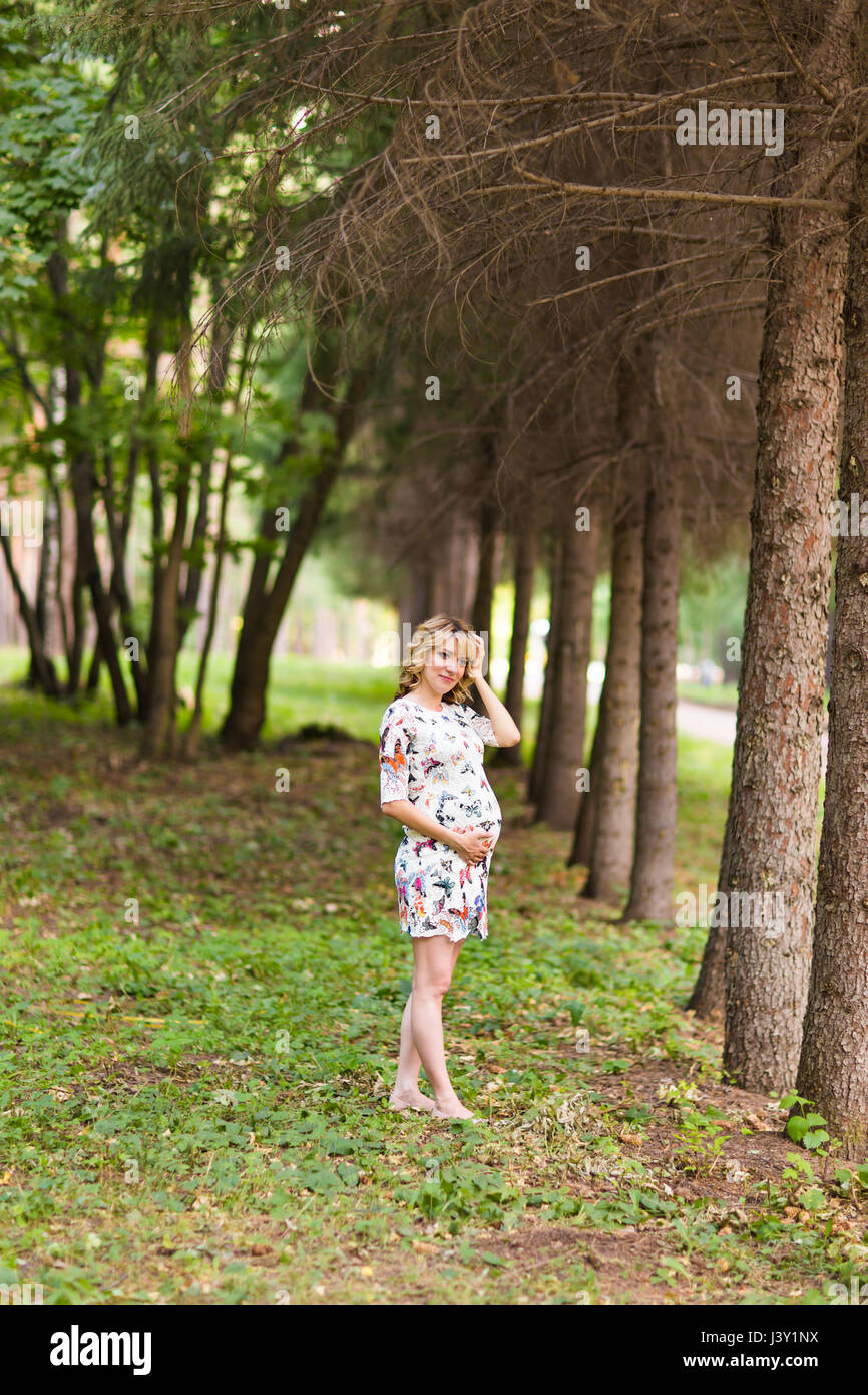 Beautiful pregnant woman touches her belly in the park Stock Photo - Alamy