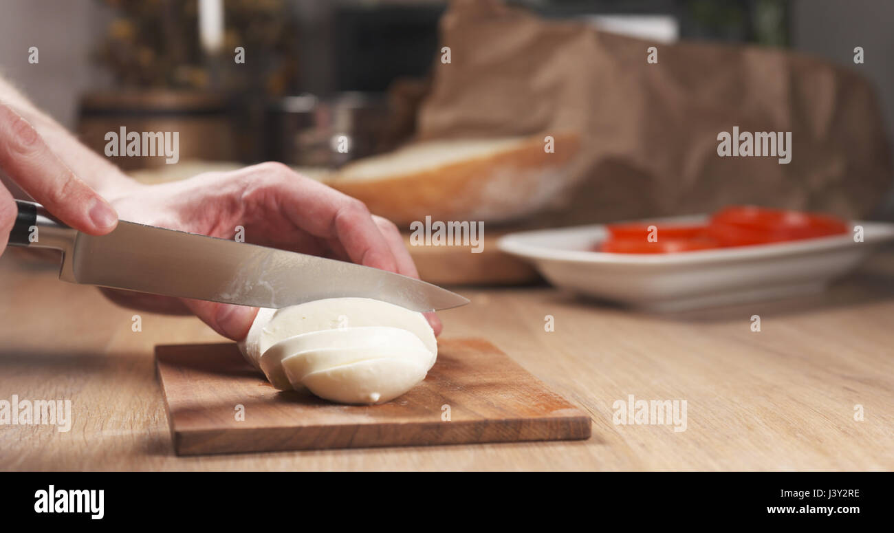 young man hands slicing mozzarella cheese Stock Photo Alamy