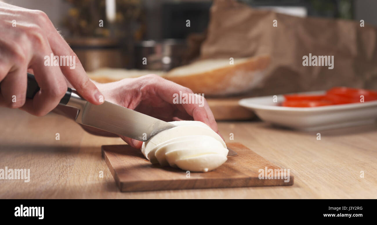 young man hands slicing mozzarella cheese Stock Photo Alamy