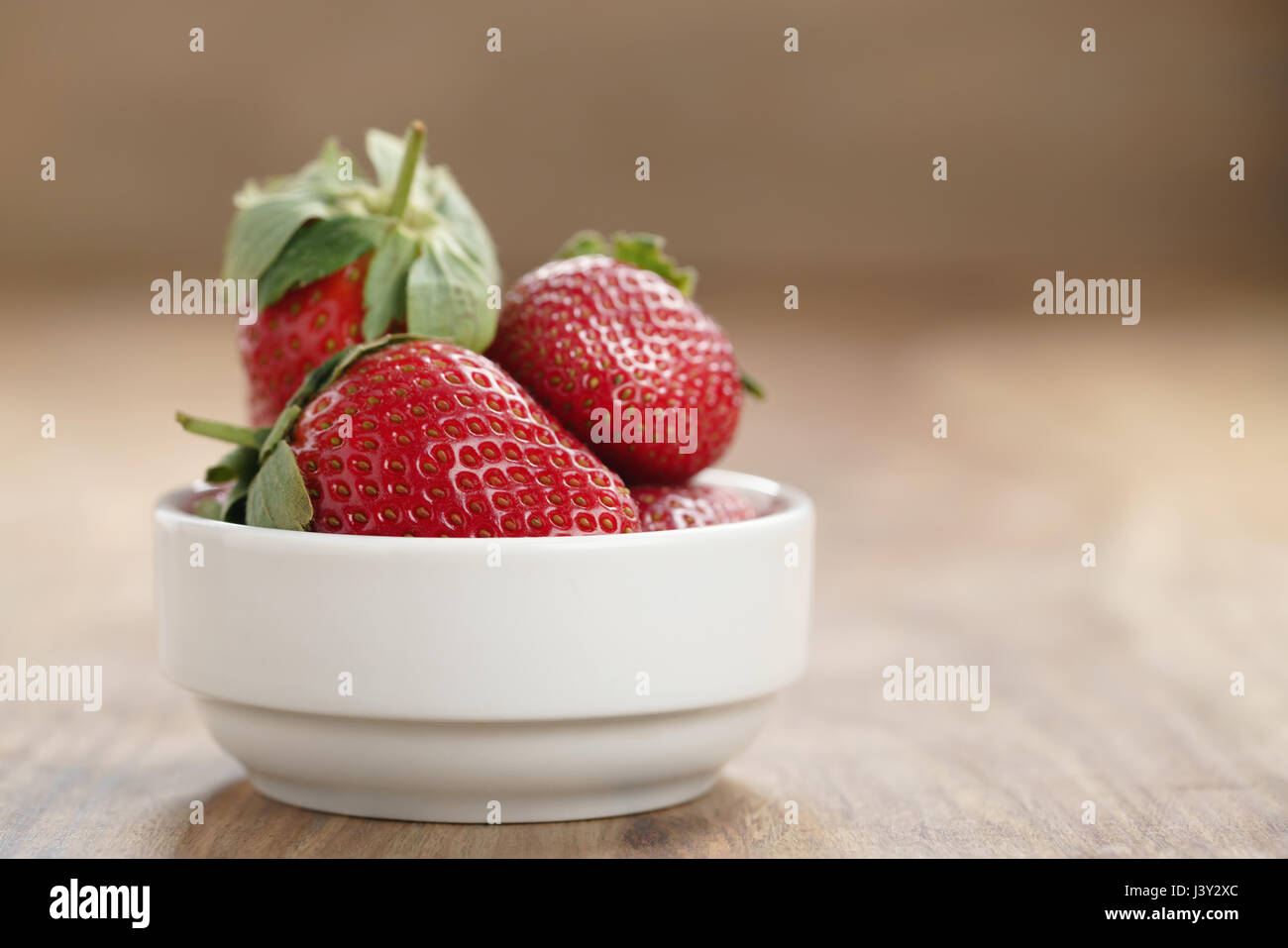 ripe organic strawberries in white bowl on wood table Stock Photo - Alamy