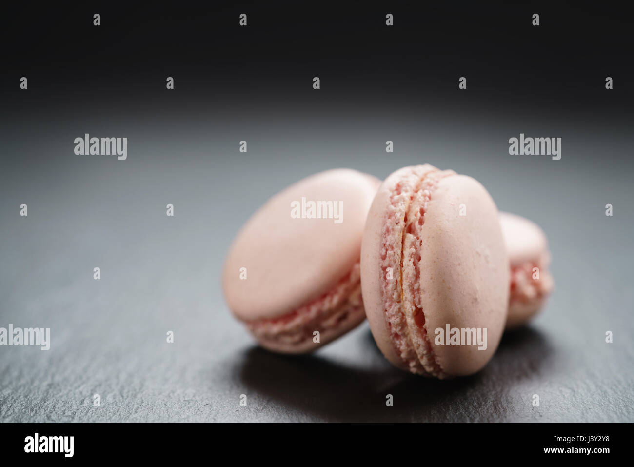 light pink macarons on slate background with copy space Stock Photo