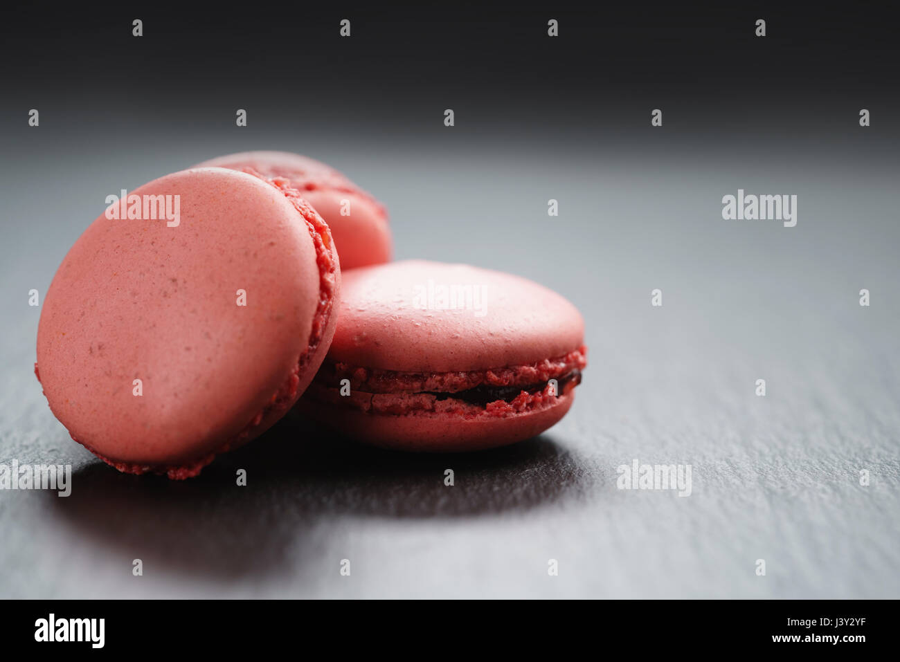 bright pink macarons on slate background with copy space Stock Photo