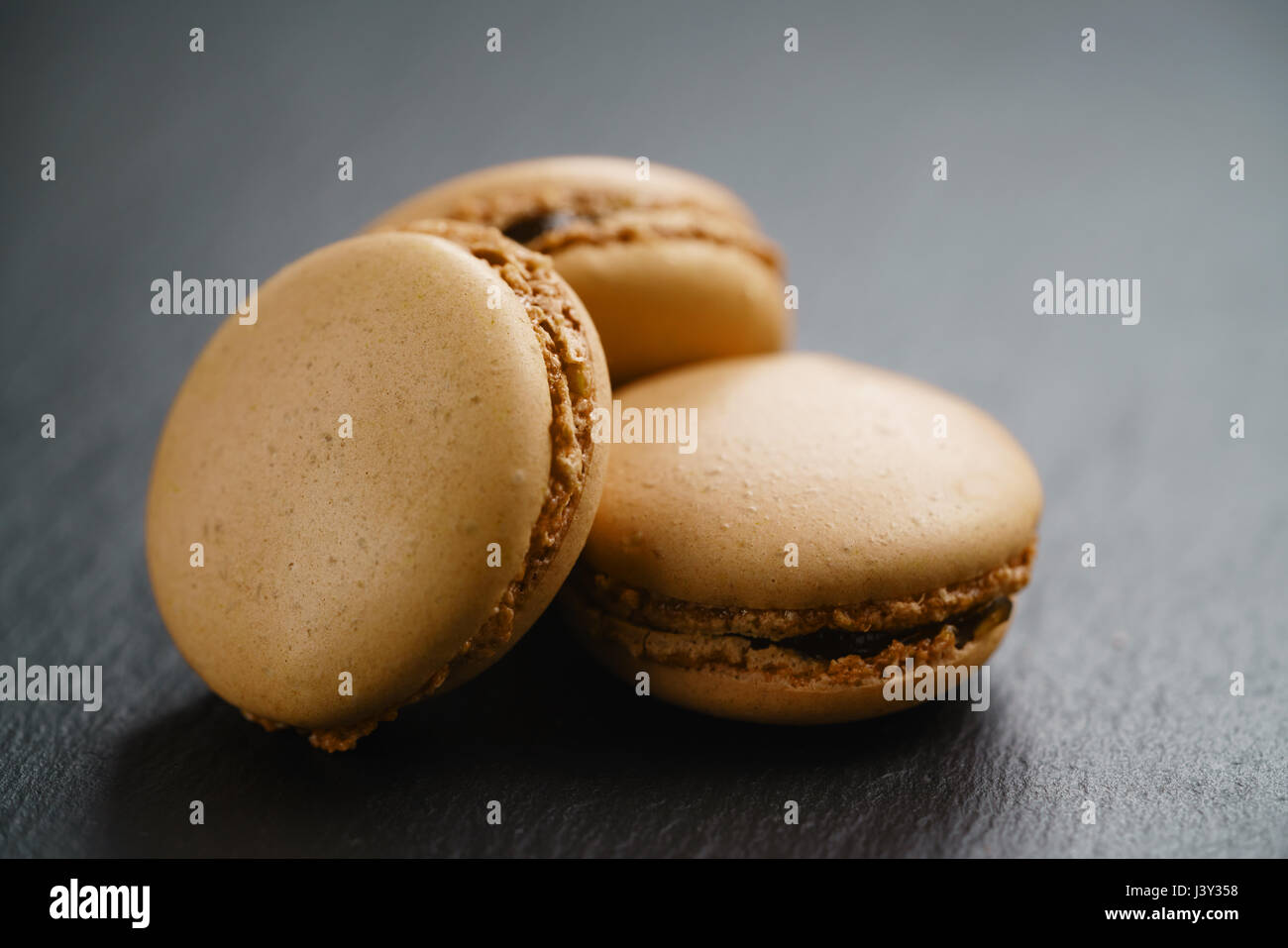 caramel brown macarons on slate background Stock Photo