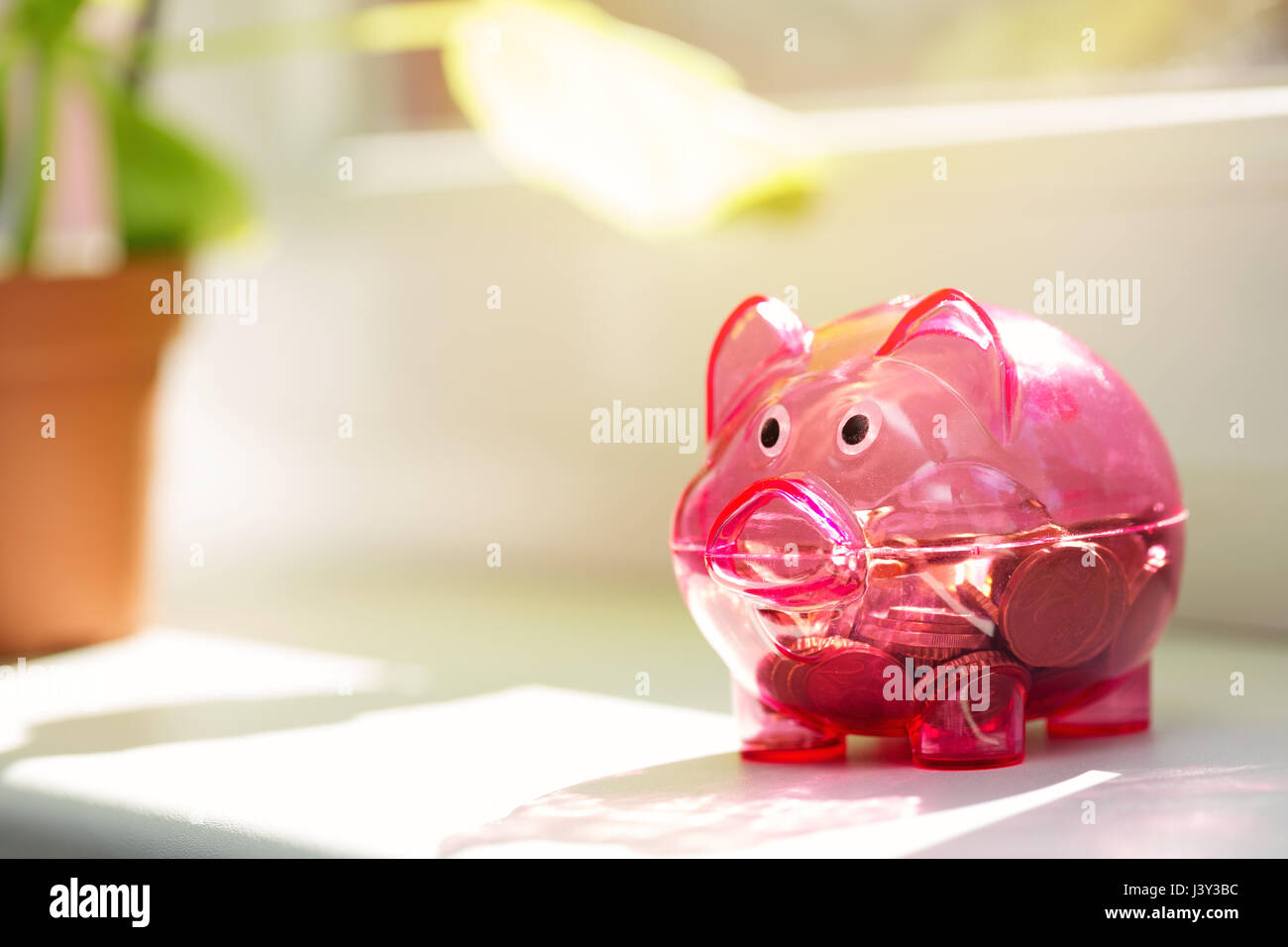 house savings - piggy bank on window sill Stock Photo