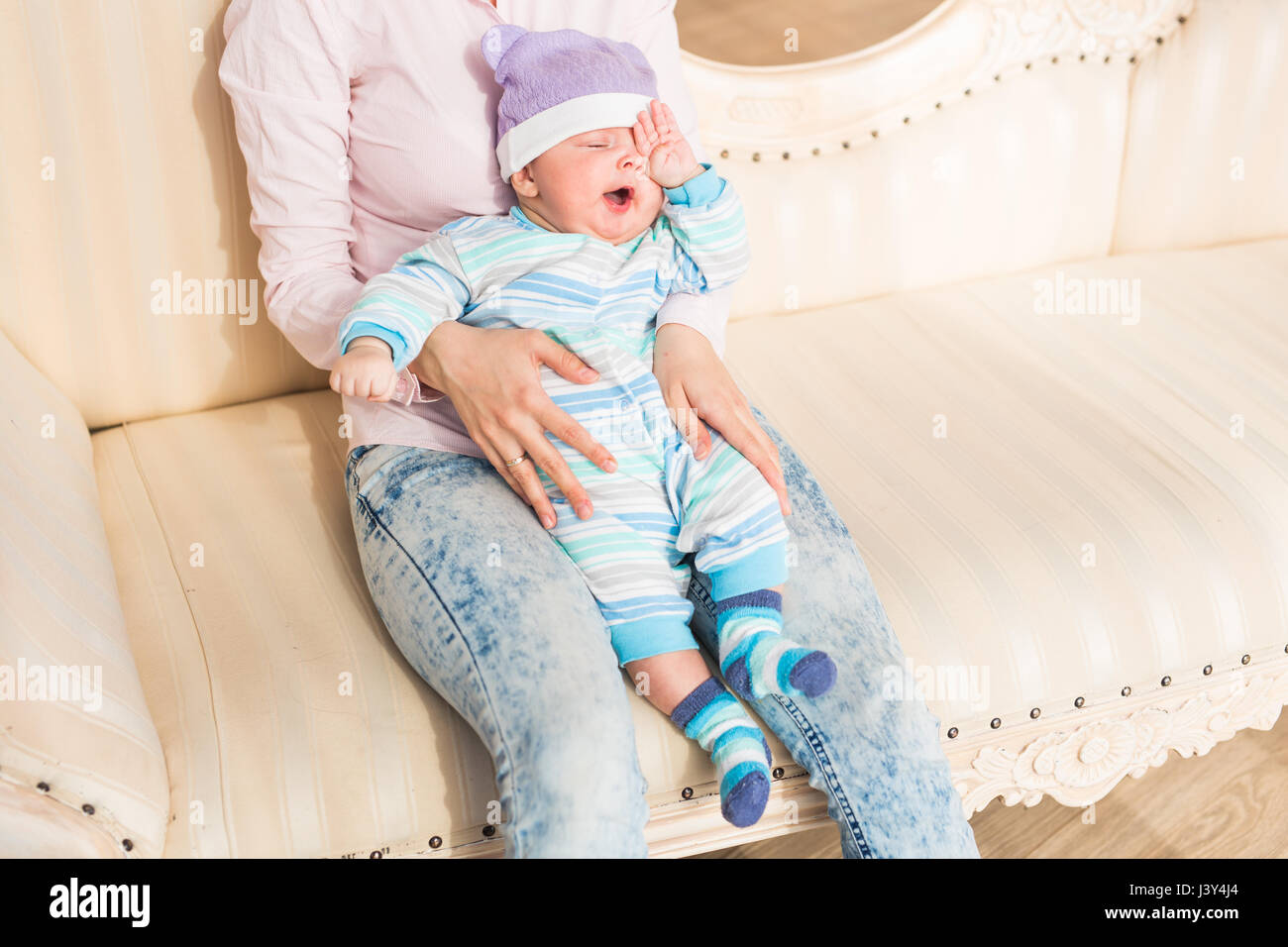 Tired newborn baby boy rubbing eyes Stock Photo Alamy