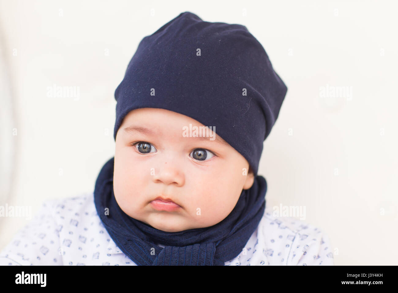 Close up portrait of cute baby boy wearing blue hat Stock Photo - Alamy