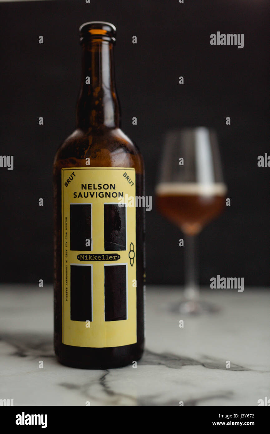 Mikkeller Nelson Sauvignon Brut Belgian Strong Ale aged in white wine barrels with a glass of beer Stock Photo