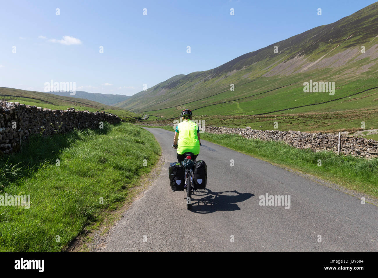 Cyclist Riding Down Barbondale on the Lakes and Dales Cycle Loop, Cumbria, Yorkshire Dales Border, UK. Stock Photo