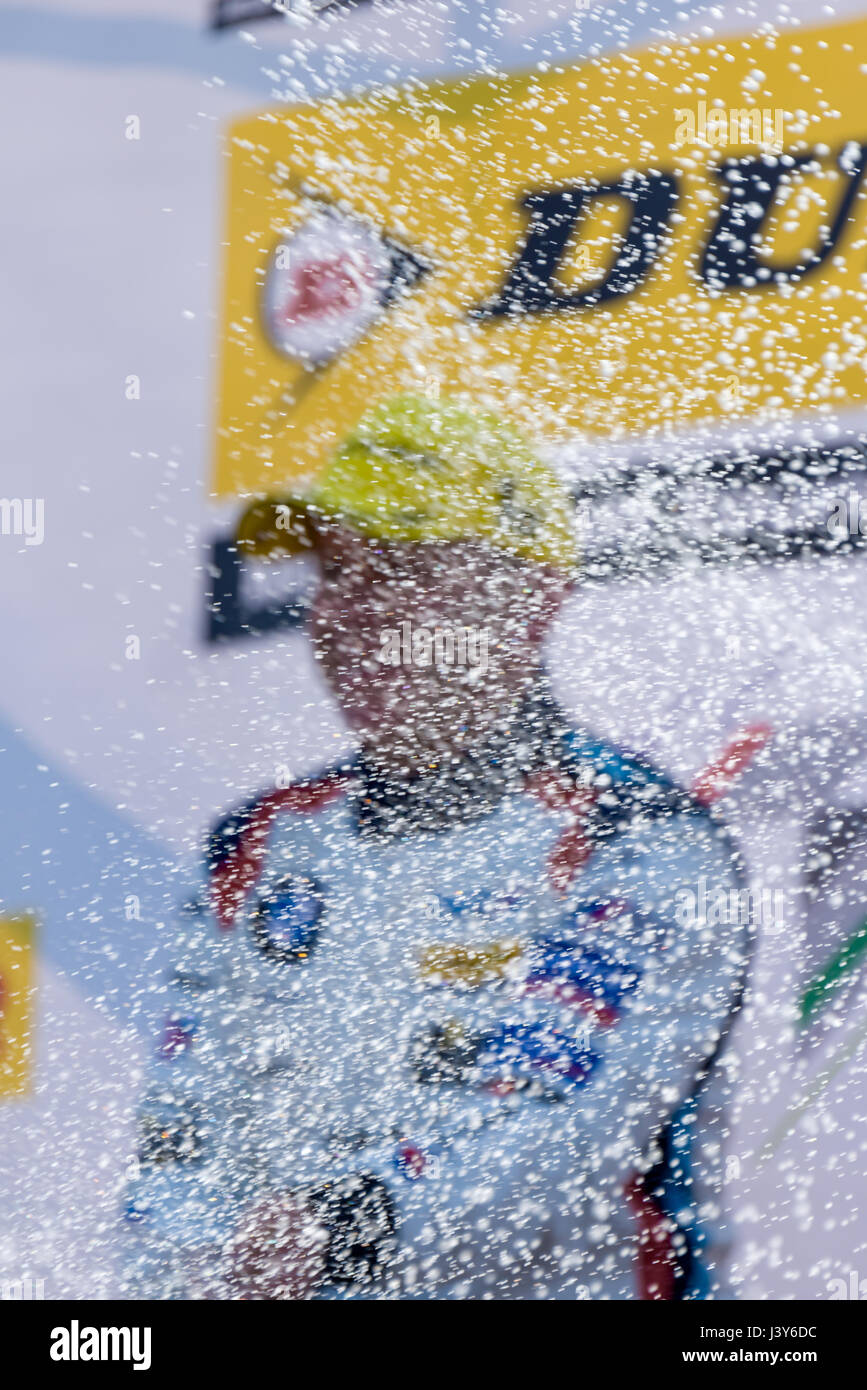 A racing driver at the British Touring Car Championship celebrates his victory by spraying Champagne from the podium. Stock Photo