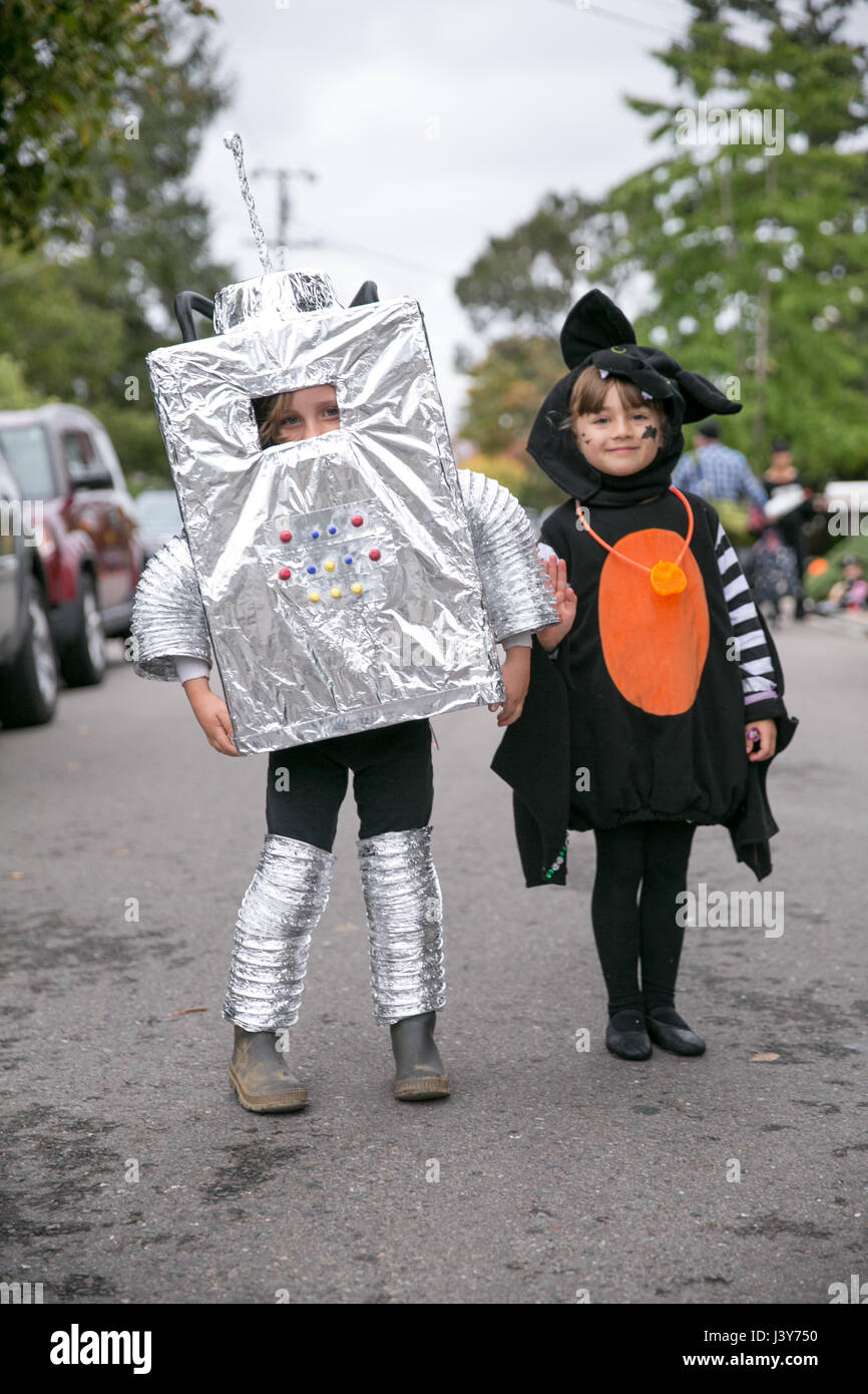 Portrait of boy in robot costume and girl in witch costume on street Stock Photo
