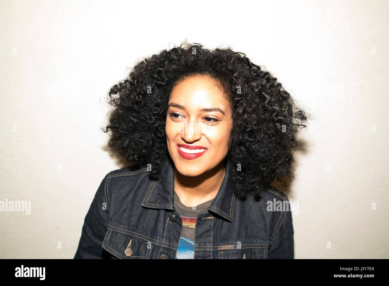 Portrait of curly haired woman looking away smiling Stock Photo