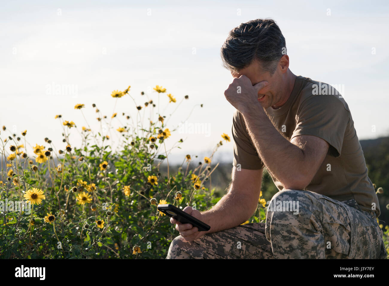 Soldier wearing combat clothing looking at smartphone, Runyon Canyon, Los Angeles, California, USA Stock Photo