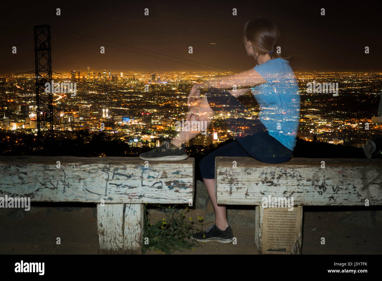 Long exposure of jogger on bench looking away at view, Runyon Canyon, Los Angeles, California, USA Stock Photo