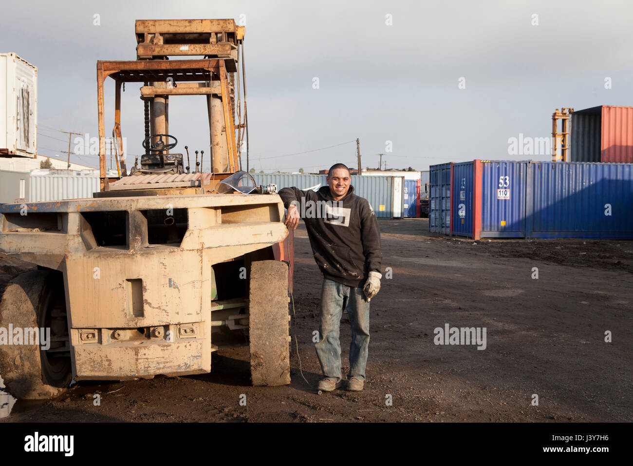 Man on construction site standing by heavy machinery Stock Photo