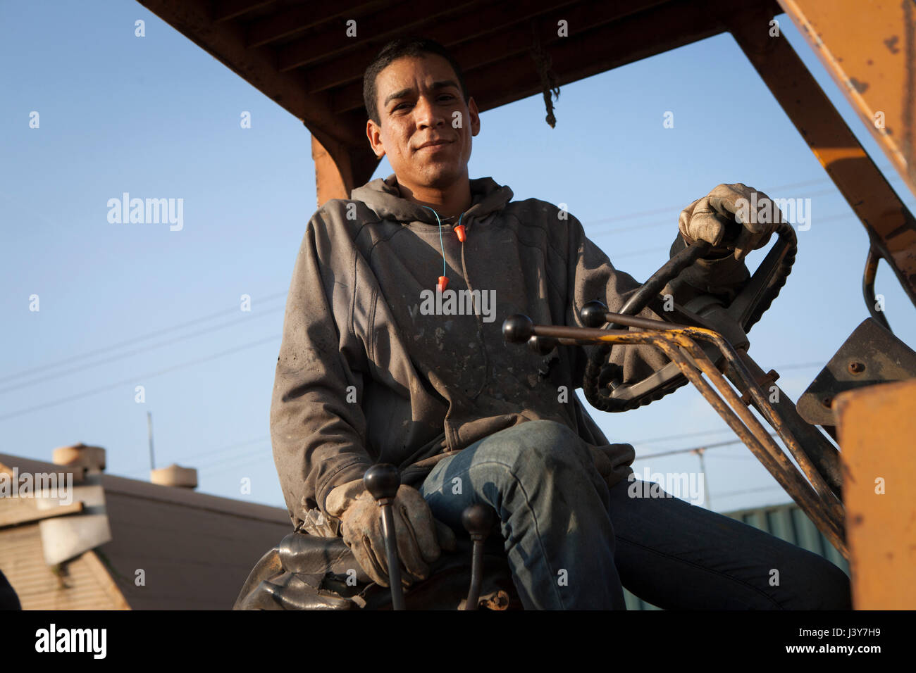Man on construction site sitting on heavy machinery Stock Photo