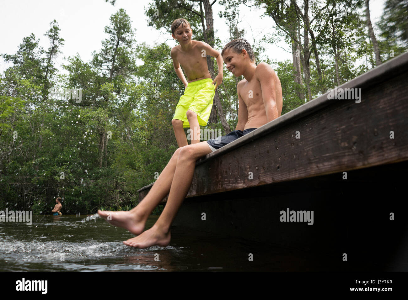 Boys wearing swimming shorts on jetty, Turkey Creek, Niceville, Florida, USA Stock Photo