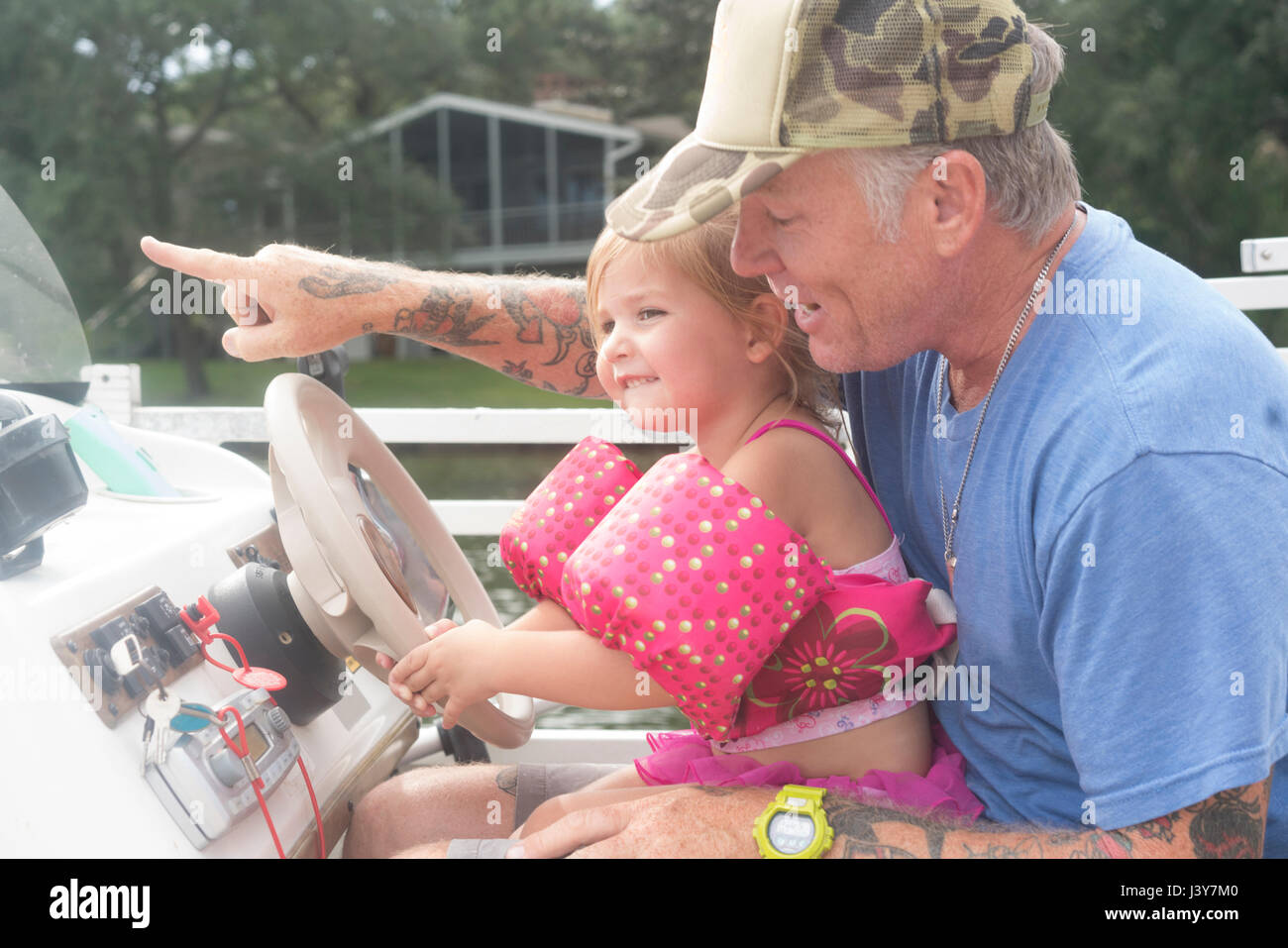 Daughter helping father to steer speed boat, Shalimar, Florida, USA Stock Photo