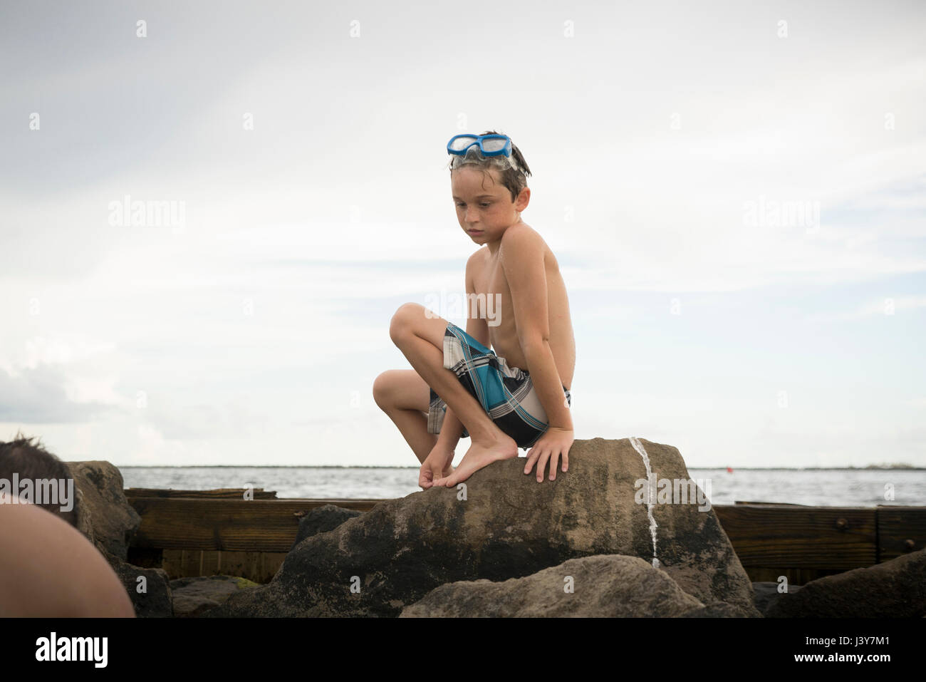 Boy rock pooling, Gulf of Mexico, Emerald Coast, Florida, USA Stock Photo