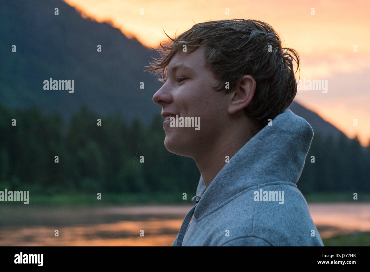 Portrait of teenage boy by river at sunset, Washington, USA Stock Photo