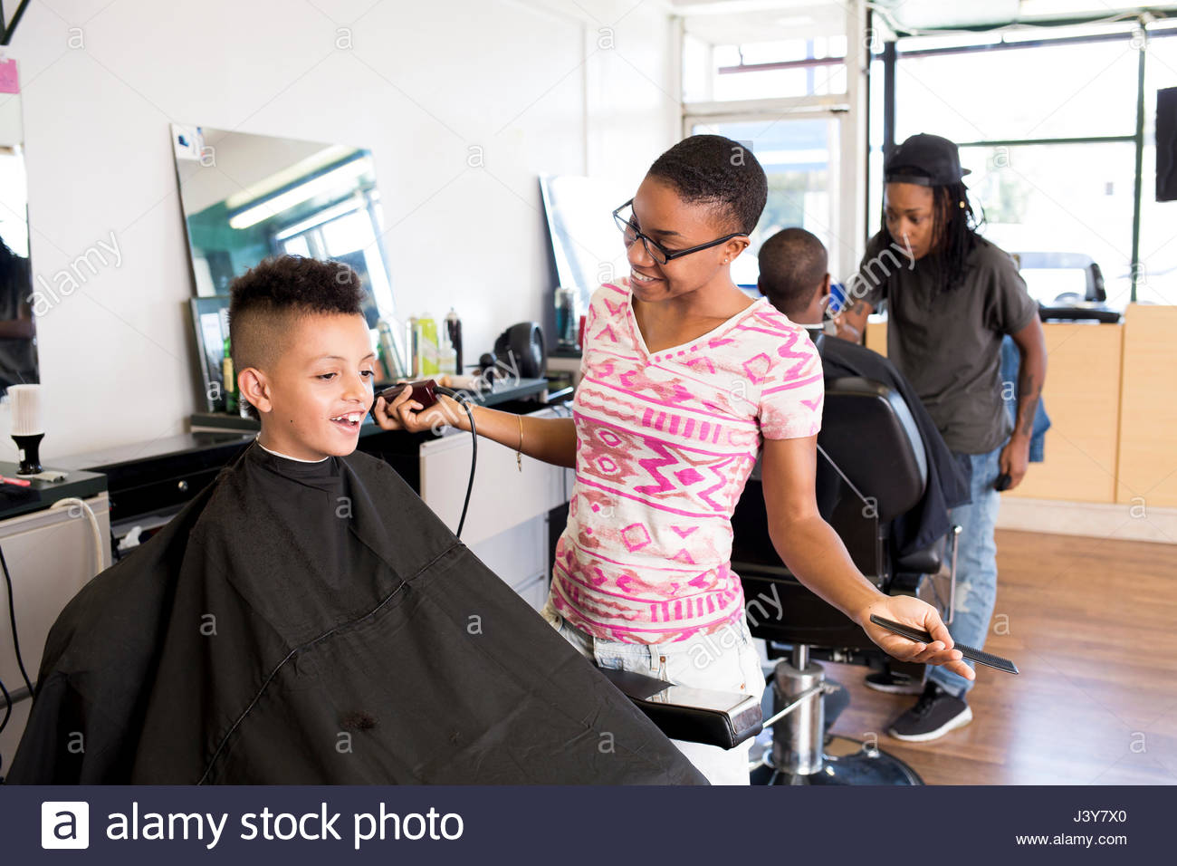 Female Barber Using Hair Clippers On Boy S Hairstyle In Barber