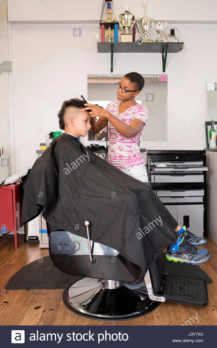 Female Barber Using Hair Clippers On Boy S Hairstyle In Barber