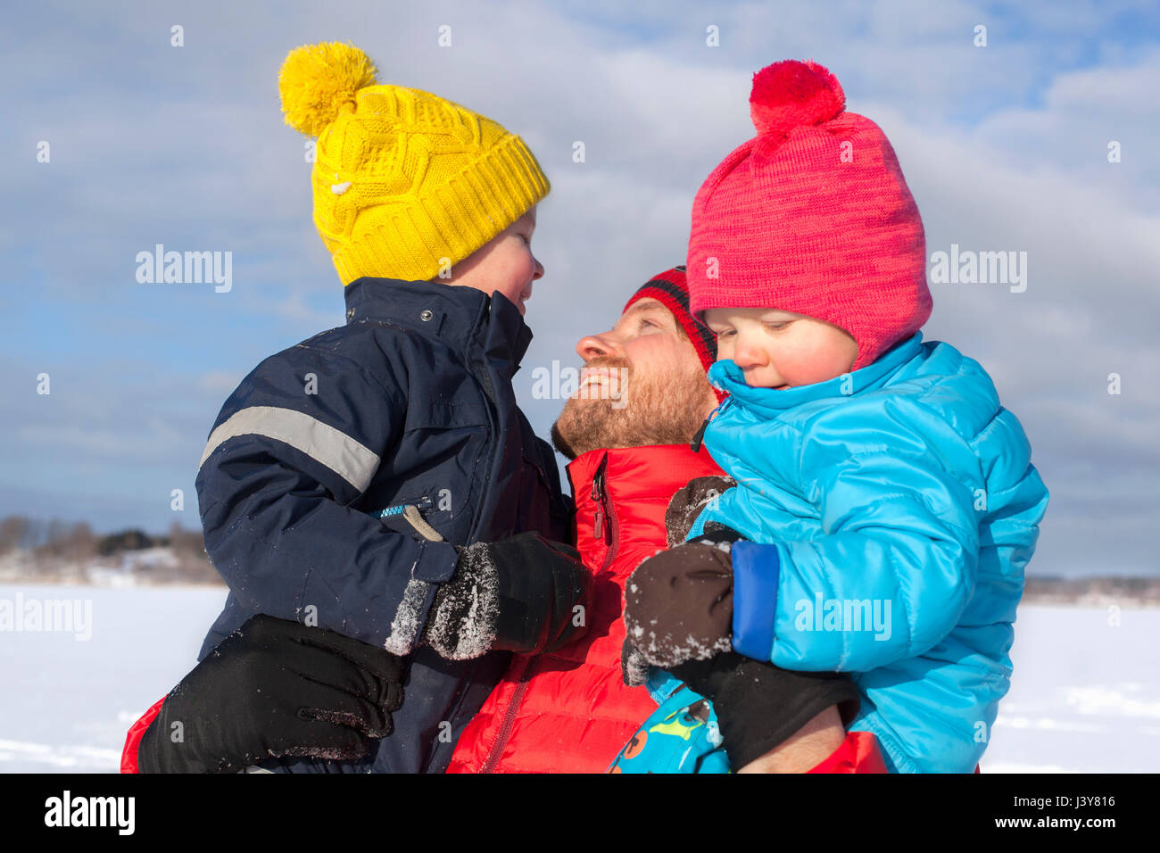 Father holding two sons, in snow covered landscape Stock Photo Alamy
