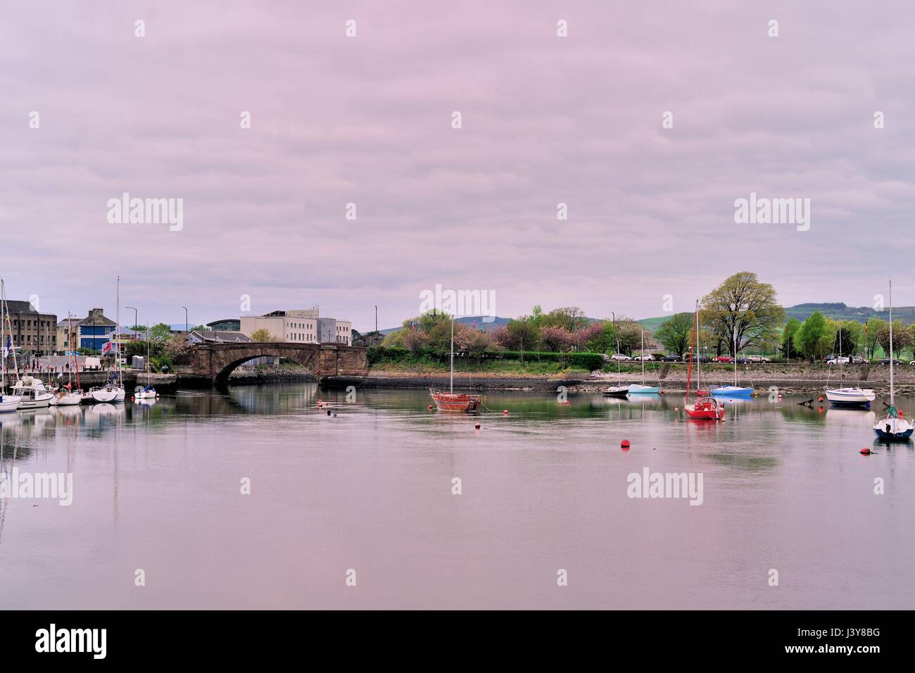 Small boats and sailboats in a colorful Dungarvan Harbor made more so by the fading colors of daylight in the Irish coastal community. Stock Photo