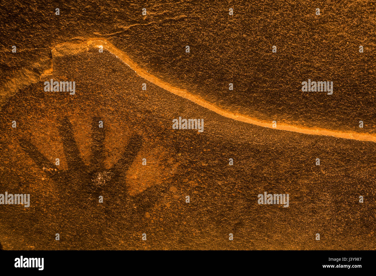 Spatter print of human hand on the sandstone walls behind Fallen Roof Ruin, with its dramatic evidence of Ancestral Puebloan habitation, Bears Ears Na Stock Photo