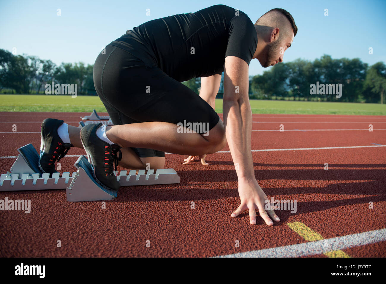 Runners preparing for race at starting blocks Stock Photo - Alamy