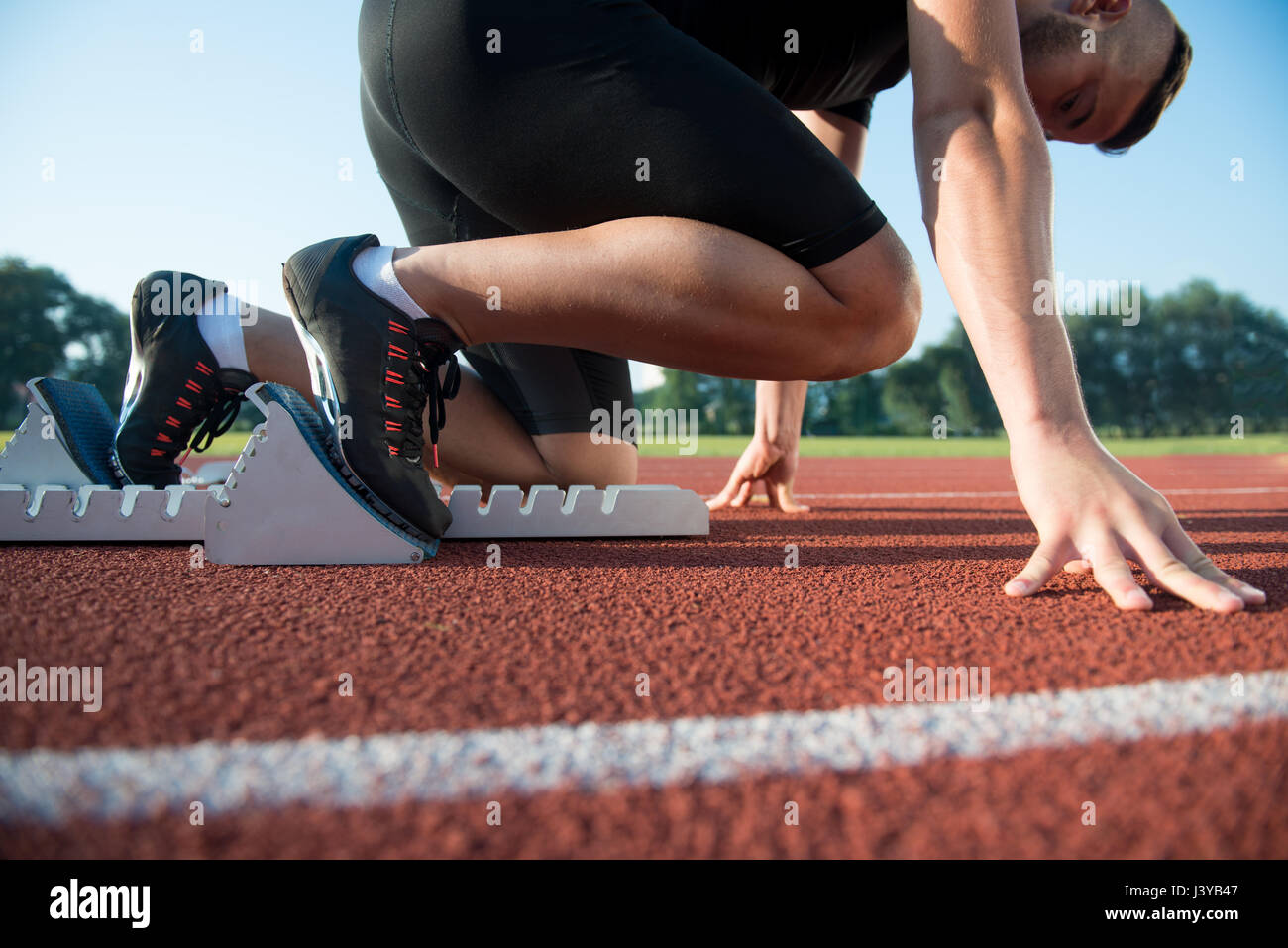 Runners preparing for race at starting blocks Stock Photo Alamy