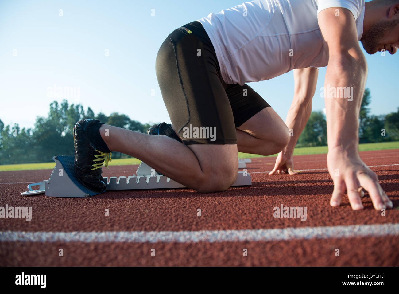 Runners preparing for race at starting blocks Stock Photo Alamy