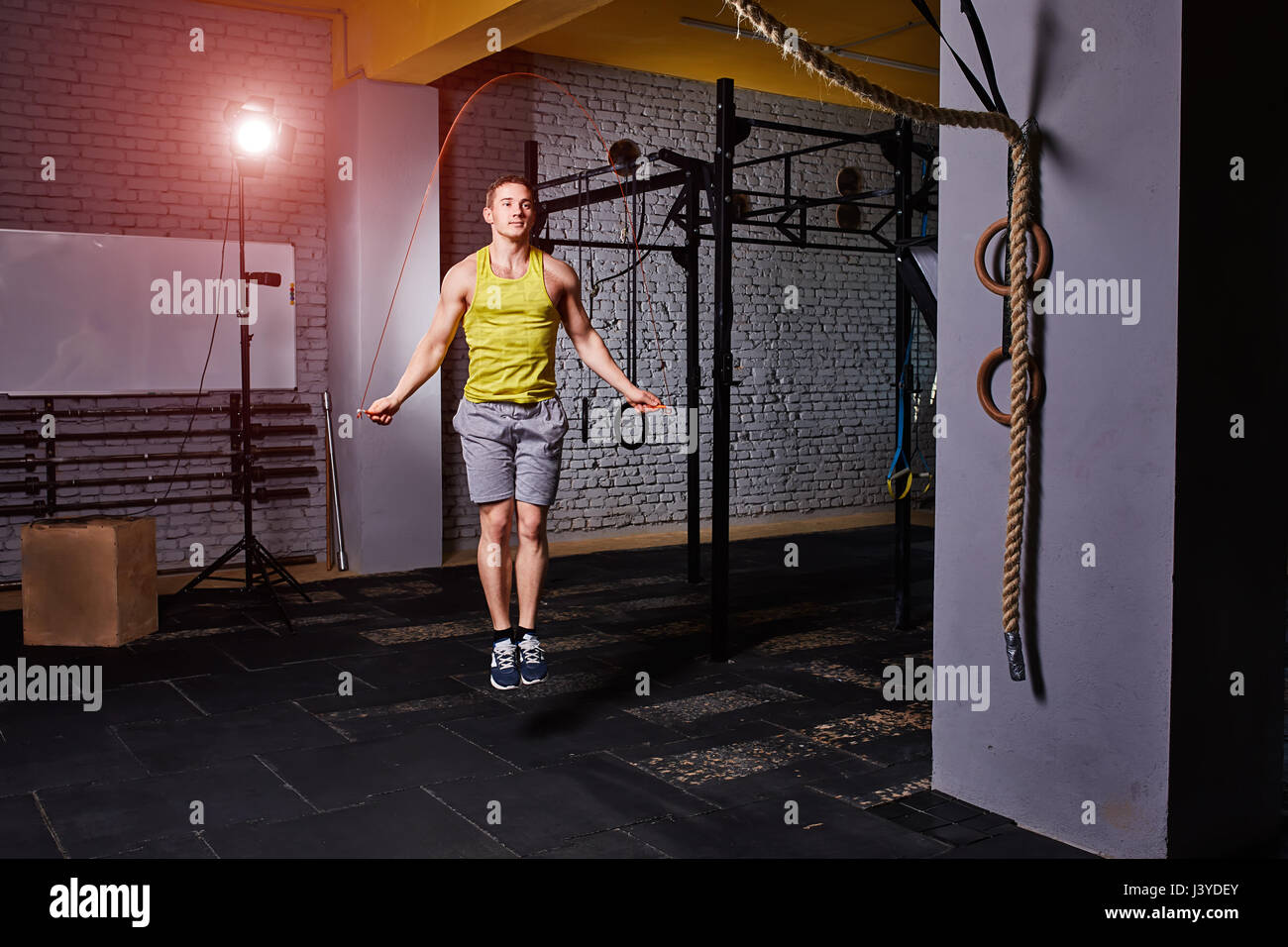 Man Using Jump Rope Model Athlete man in the sportwear using jump ropes for the workout in a ...