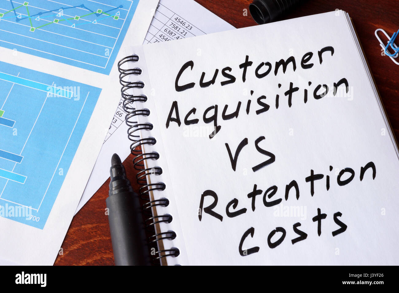 Customer Acquisition vs Retention Costs written in a note. Stock Photo