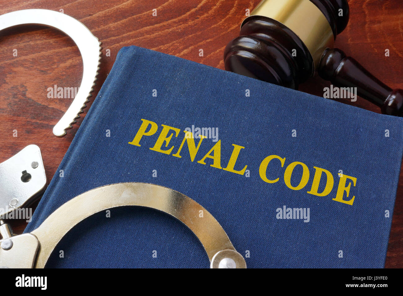 Cuffs and book with the title Penal code. Criminal law concept. Stock Photo