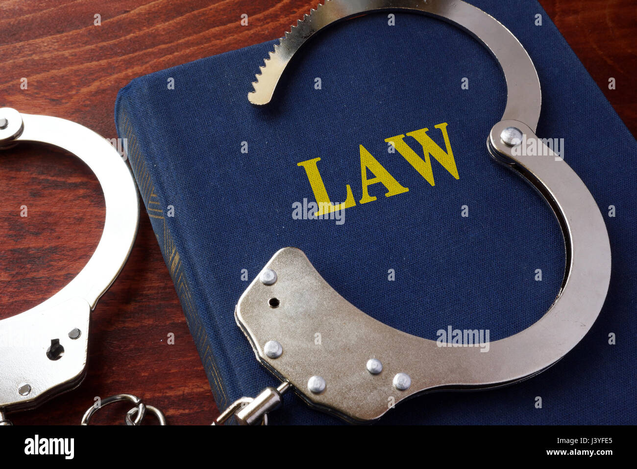 Cuffs and book with the title Law. Stock Photo