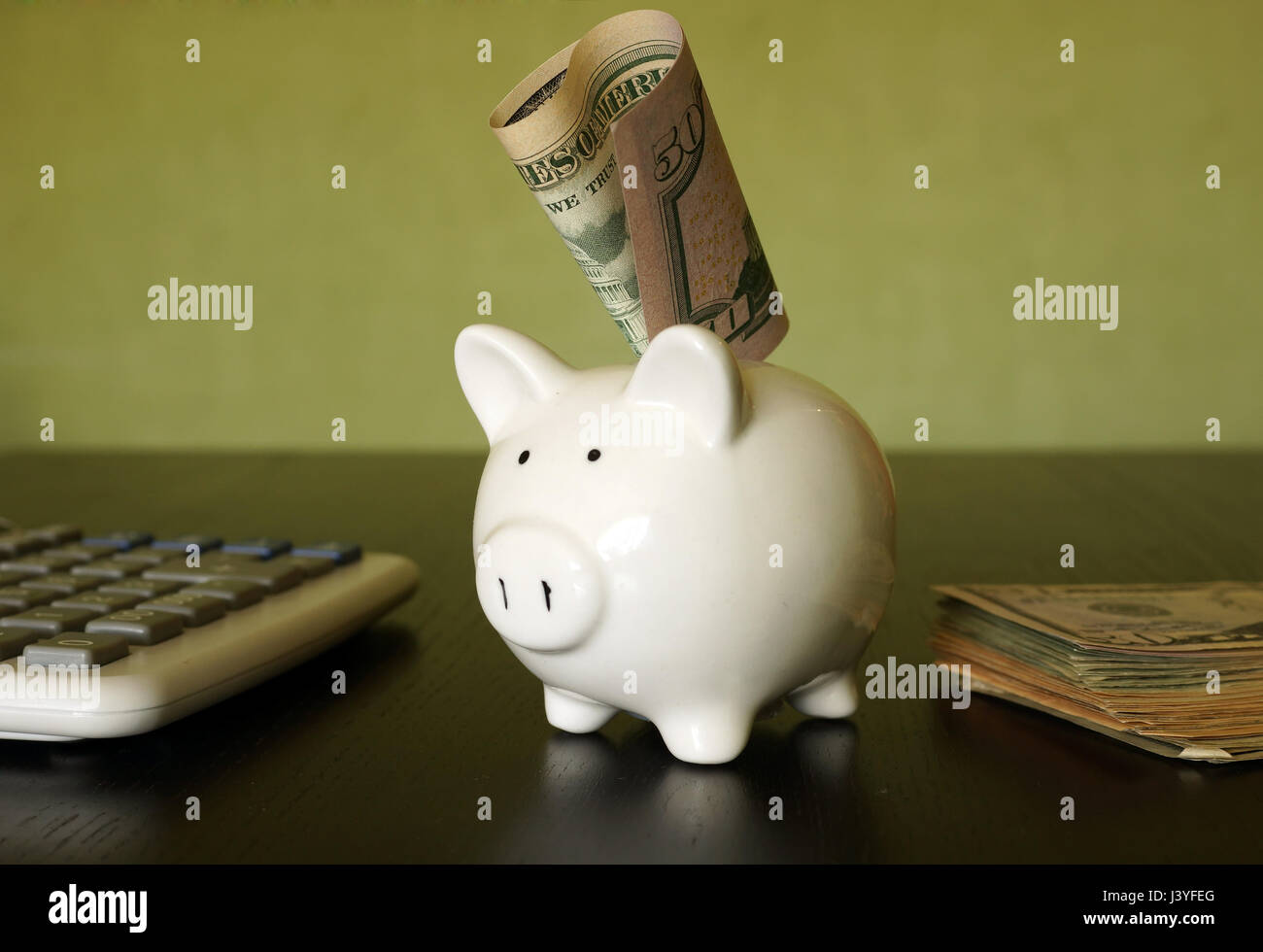 Savings concept. Piggy bank, calculator and dollars. Stock Photo