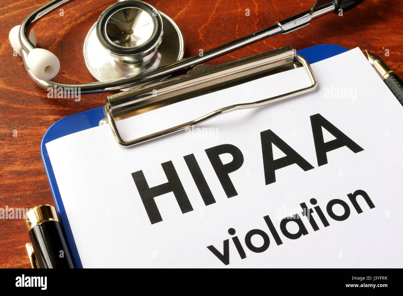 HIPAA violation form on a clipboard. Medical confidentiality concept. Stock Photo