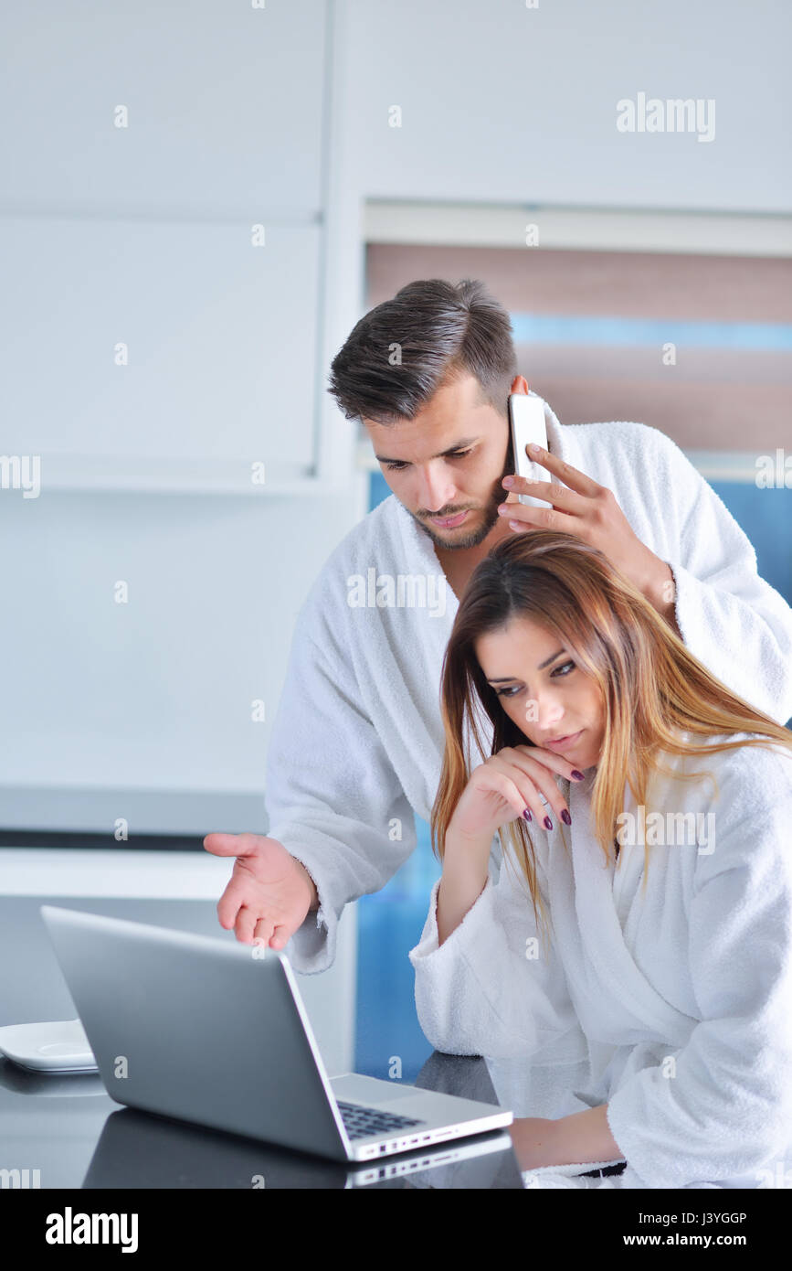 Portrait of a couple in the kitchen and using a laptop Stock Photo - Alamy