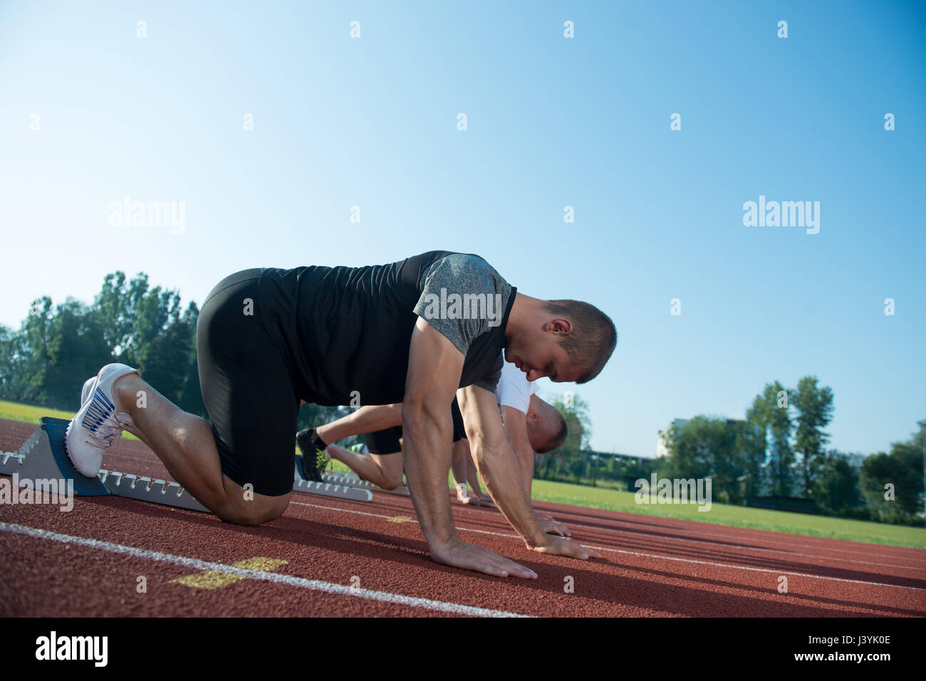 Runners preparing for race at starting blocks Stock Photo Alamy