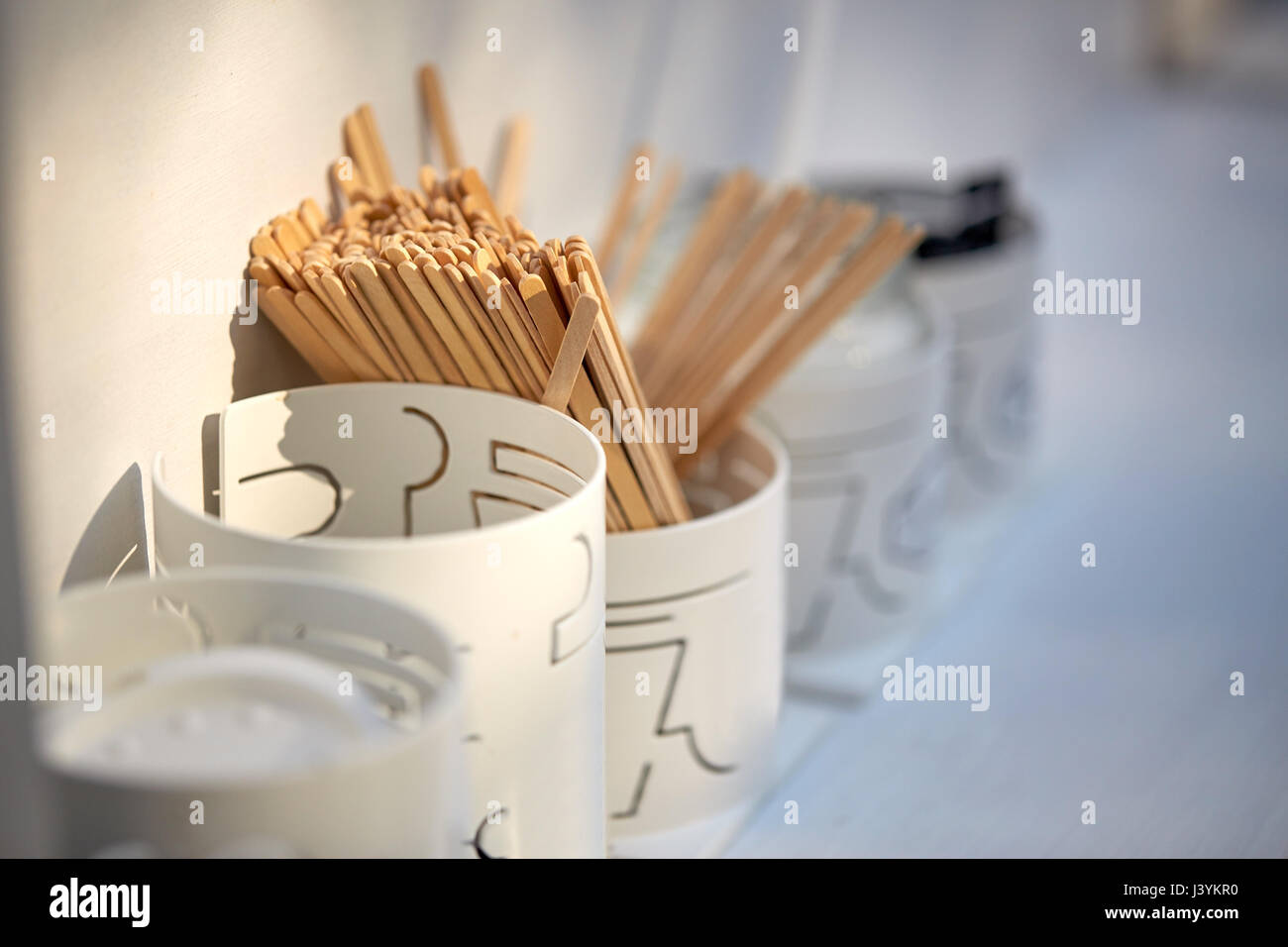 wooden drink stirrers in holder on table Stock Photo Alamy