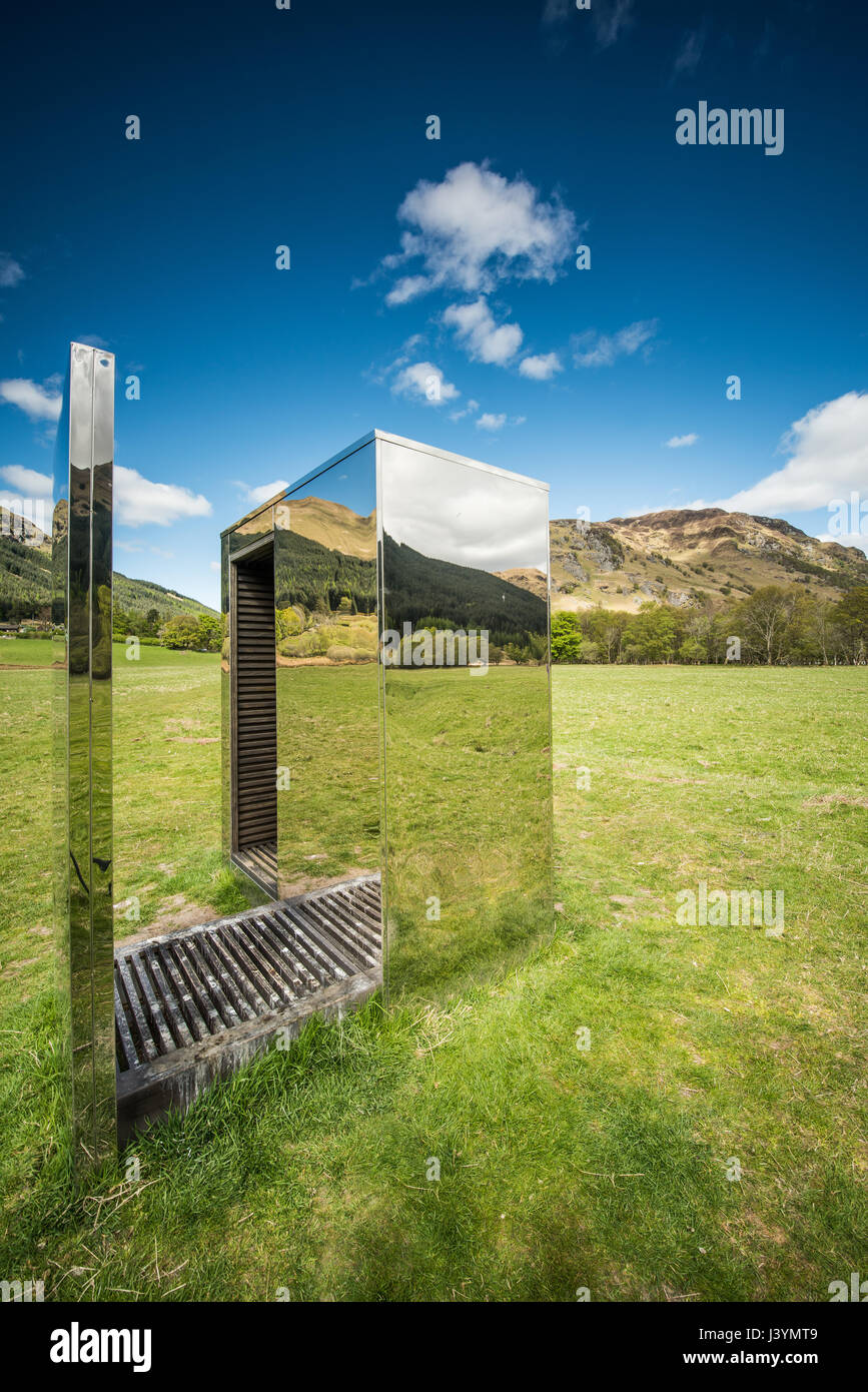 The mirrored Cabin sits on a narrow strip of land between Loch Voil and Loch Doine, reflecting and framing the water, mountains and glens that surroun Stock Photo